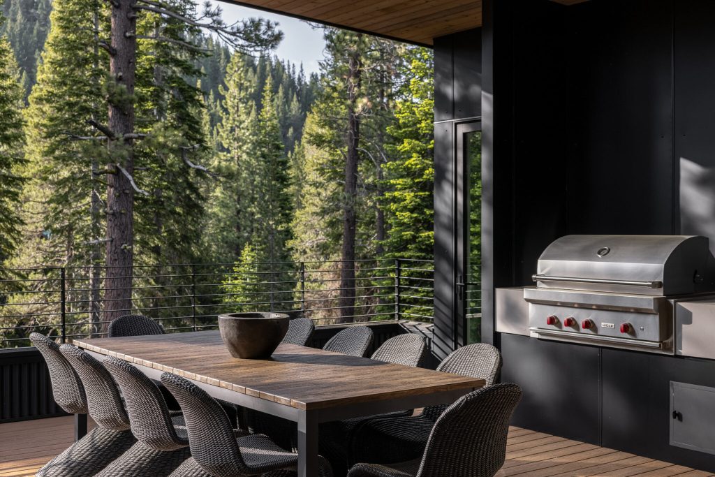 A view of a table inside a vacation rental looking out into a wooded background.