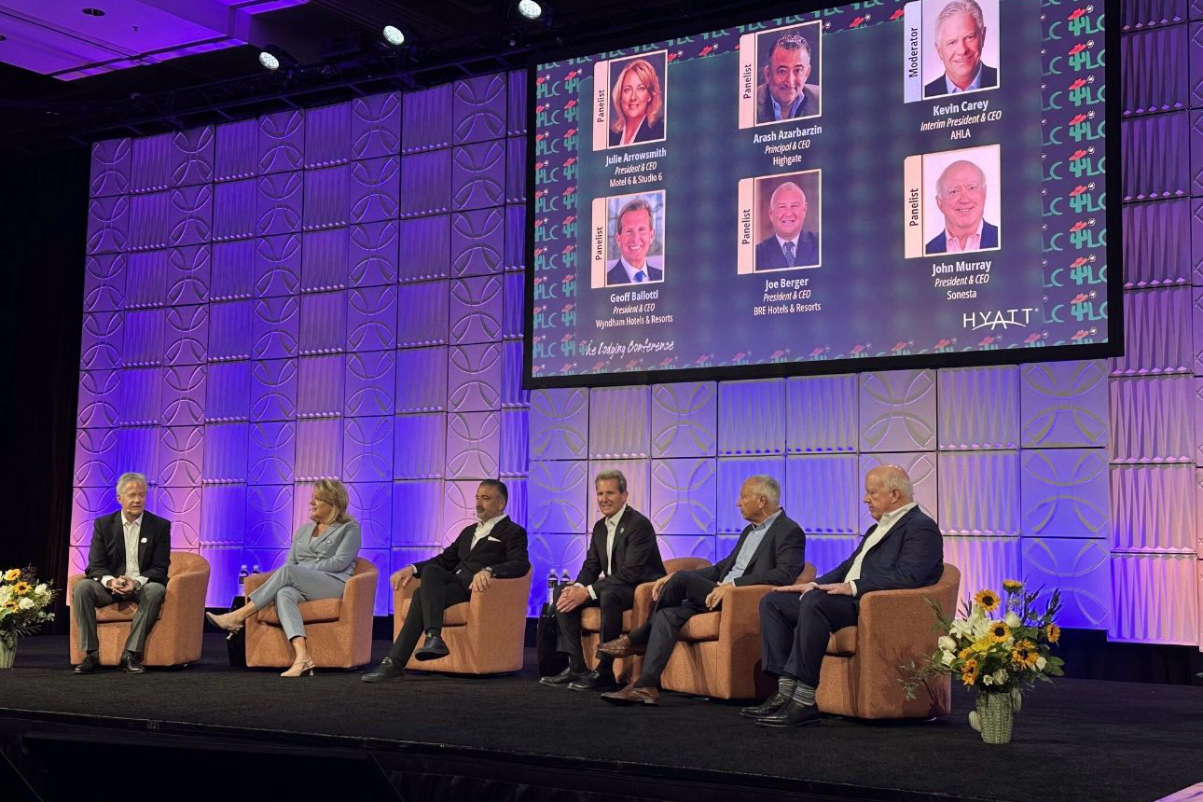 hotel executives on stage at a conference