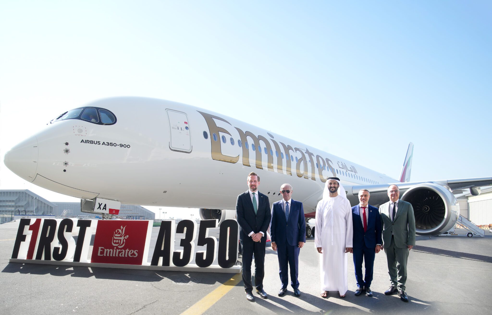 Executives stand in front of Emirates' first Airbus A350 aircraft.