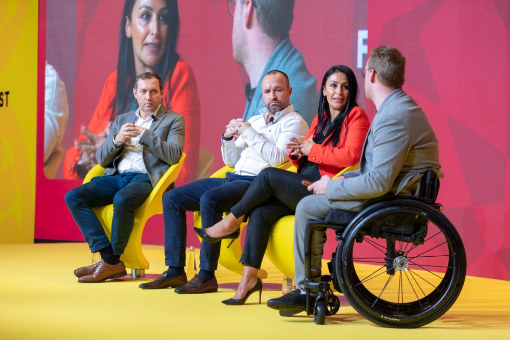 Men and women on stage at a conference.