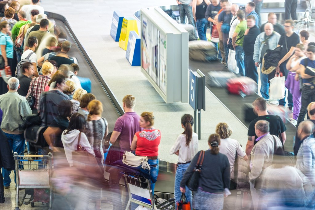 People gathered around a luggage belt at an airport