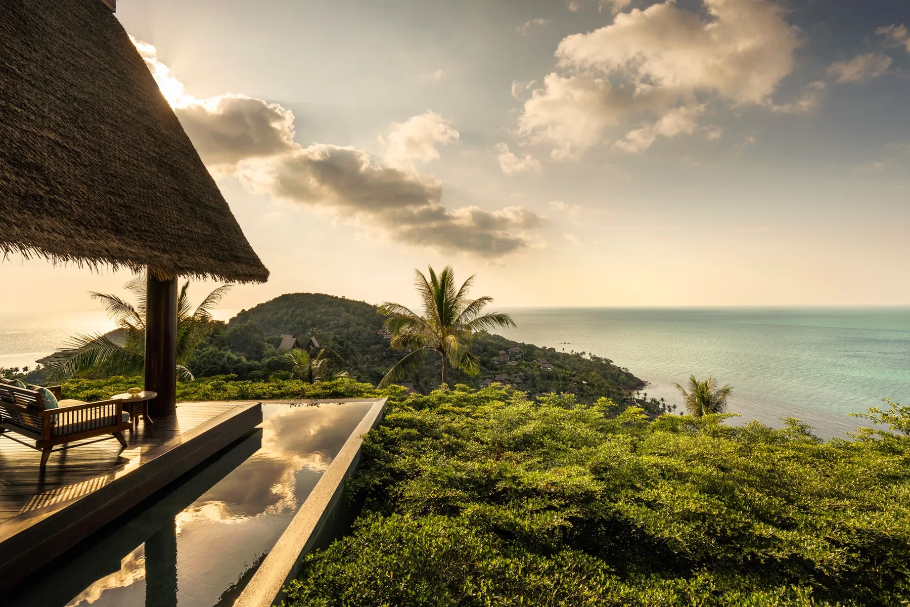 View of green forests and a sea from a hotel patio