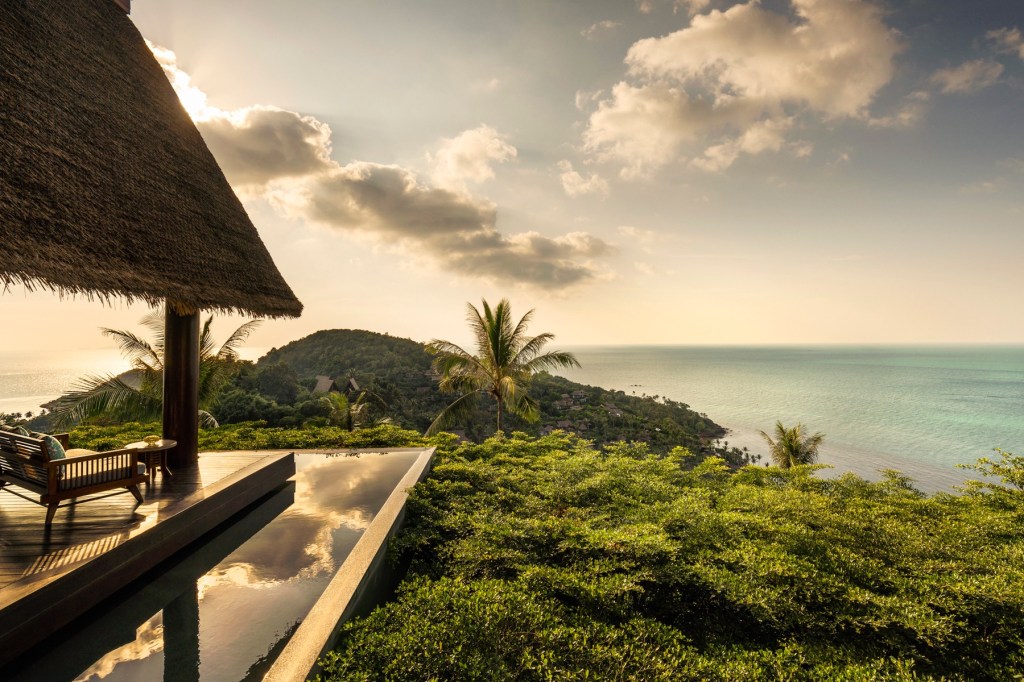 View of green forests and a sea from a hotel patio