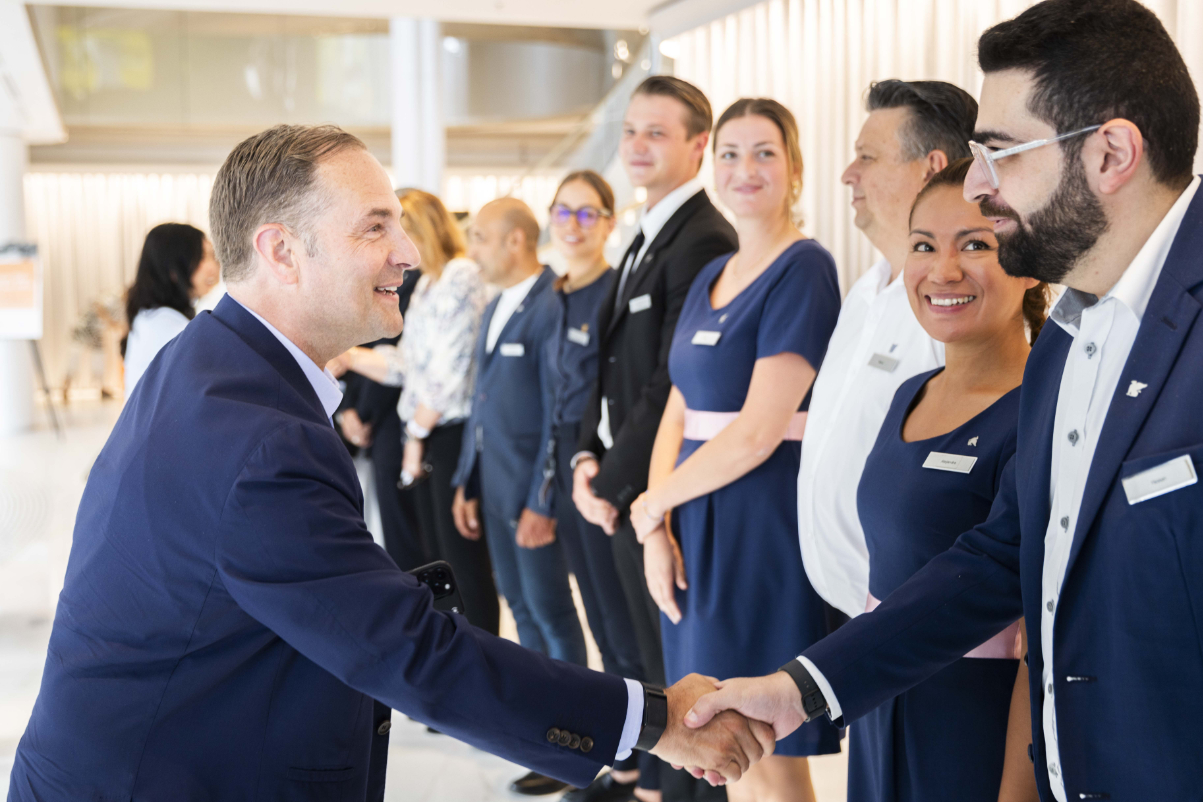 ceo of marriott greets hotel workers who are wearing uniforms