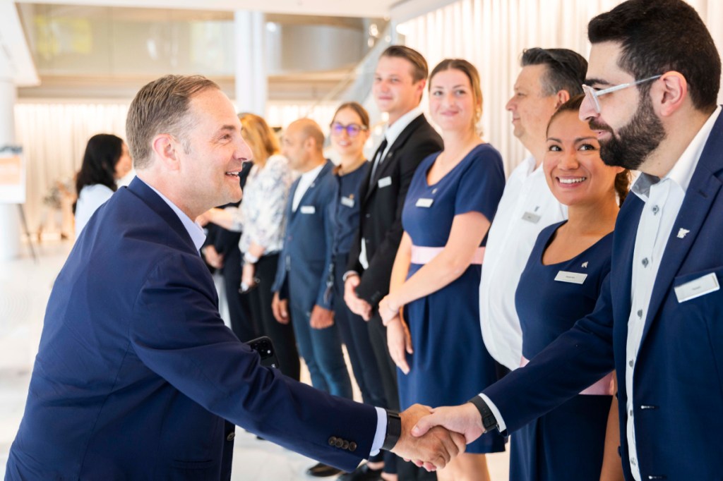 ceo of marriott greets hotel workers who are wearing uniforms