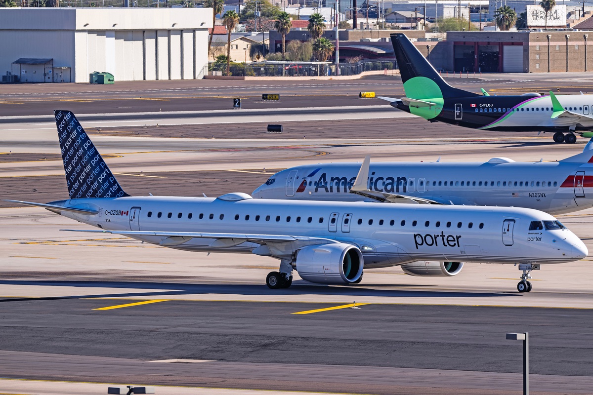 Planes passing each other on a tarmac.