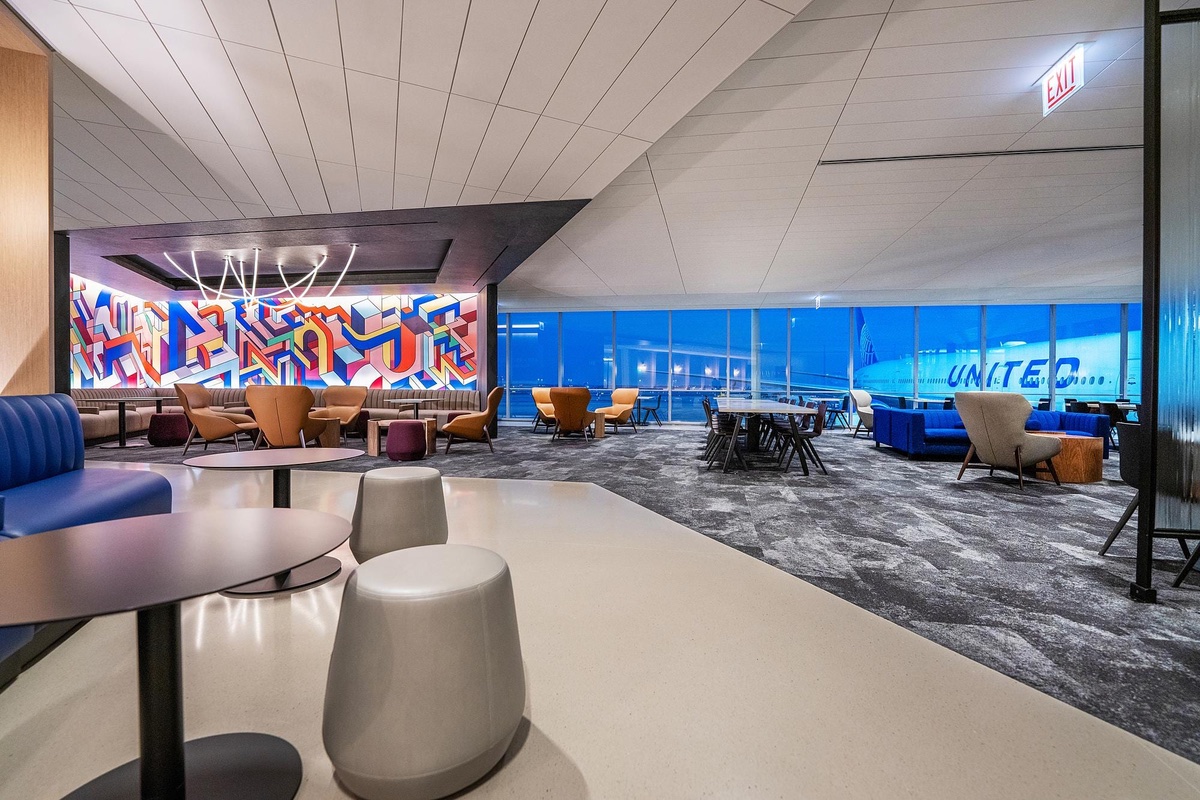 View of an airport lounge with a plane, appearing outside the windows.