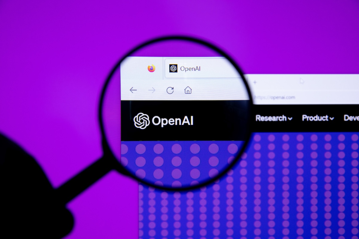 An OpenAI tab on a computer as viewed through a magnifying glass.