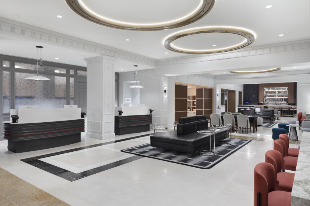 a hotel lobby after a renovation in late 2024 with lots of marble and comfy leather furniture