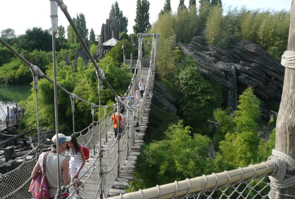 People walking on a footbridge at Disneyland Paris.