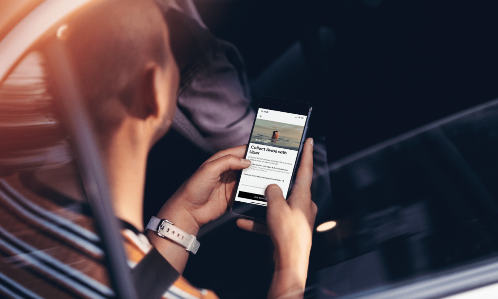An Uber customer in a car with Avios on their cell phone.