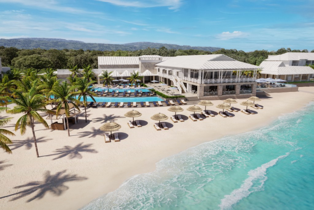 Image of a white sandy beach with the tropical waters in Jamaica on a sunny day with a luxury resort.